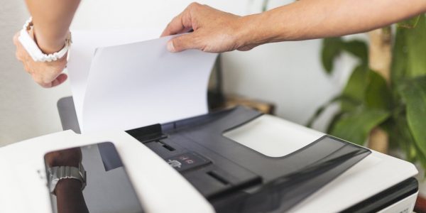 Une personne qui prend une feuille de papier dans une imprimante